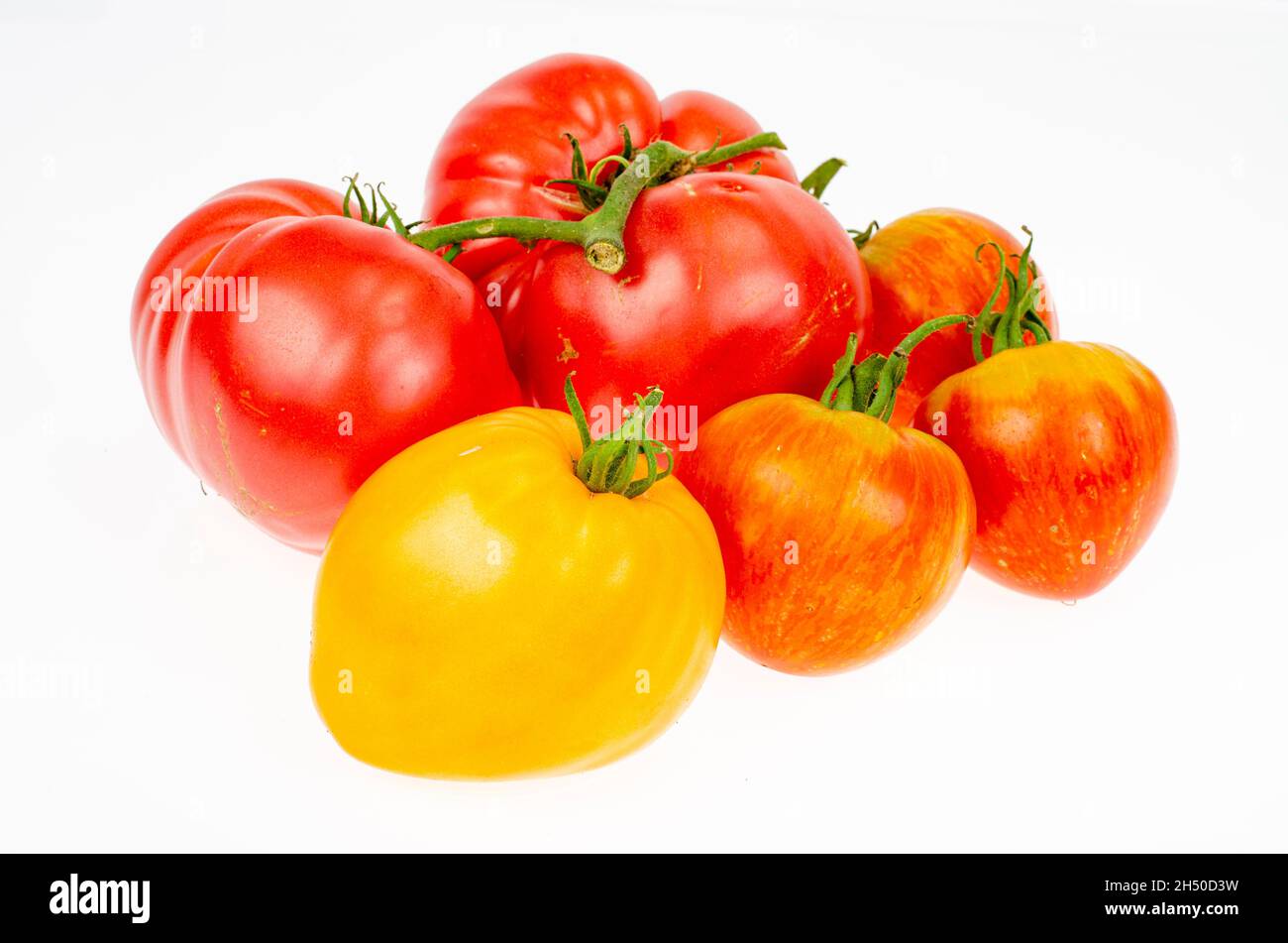 Tomatoes of different varieties and colors on white background ...