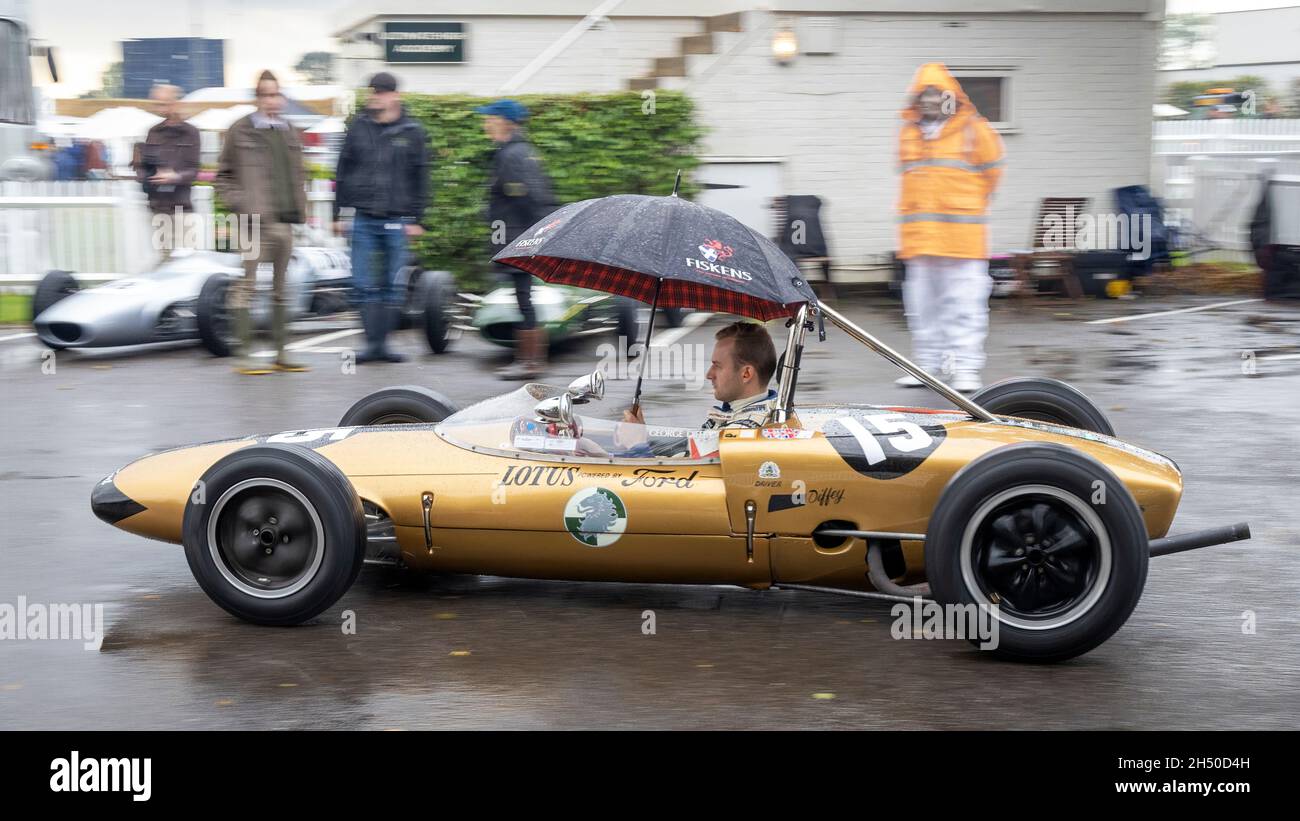 1961 Lotus-Ford 20 with driver George Diffey arrives into the wet holding paddock at the Goodwood 78th Members Meeting, Sussex, UK. Arundell Cup racer Stock Photo