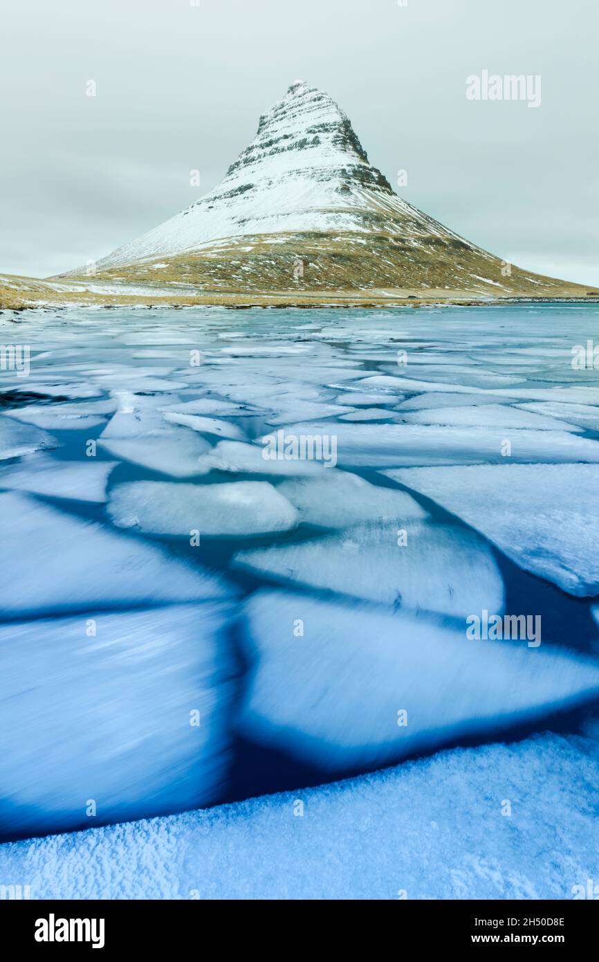 Moviing ice flioes below Kirkjufell mountain during winter on the Snæfellsnesnes peninsula in the Western part of Iceland Stock Photo