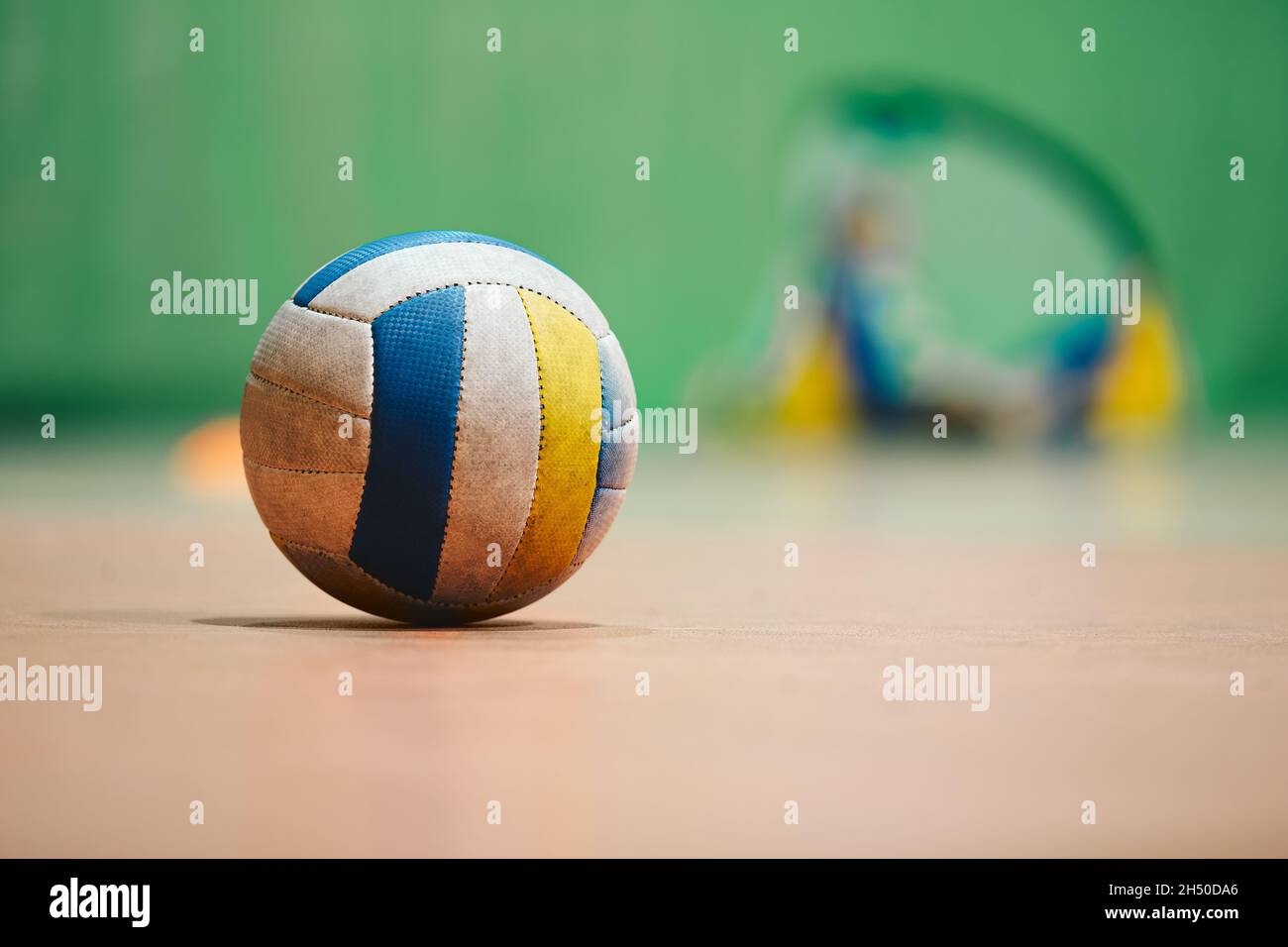 Volleyball on wooden court. Sports ball lying on indoor stadium parquet Stock Photo