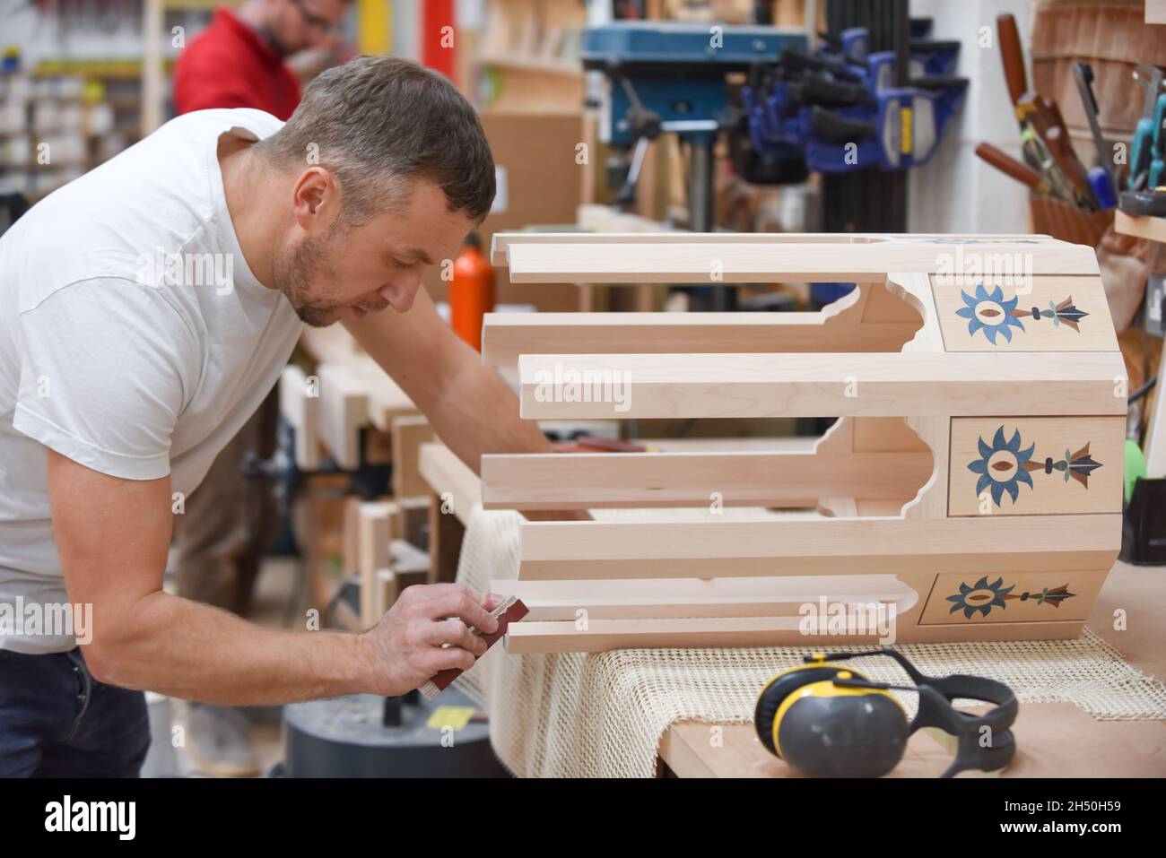 A man is making bespoke furniture in a woodwork showing the