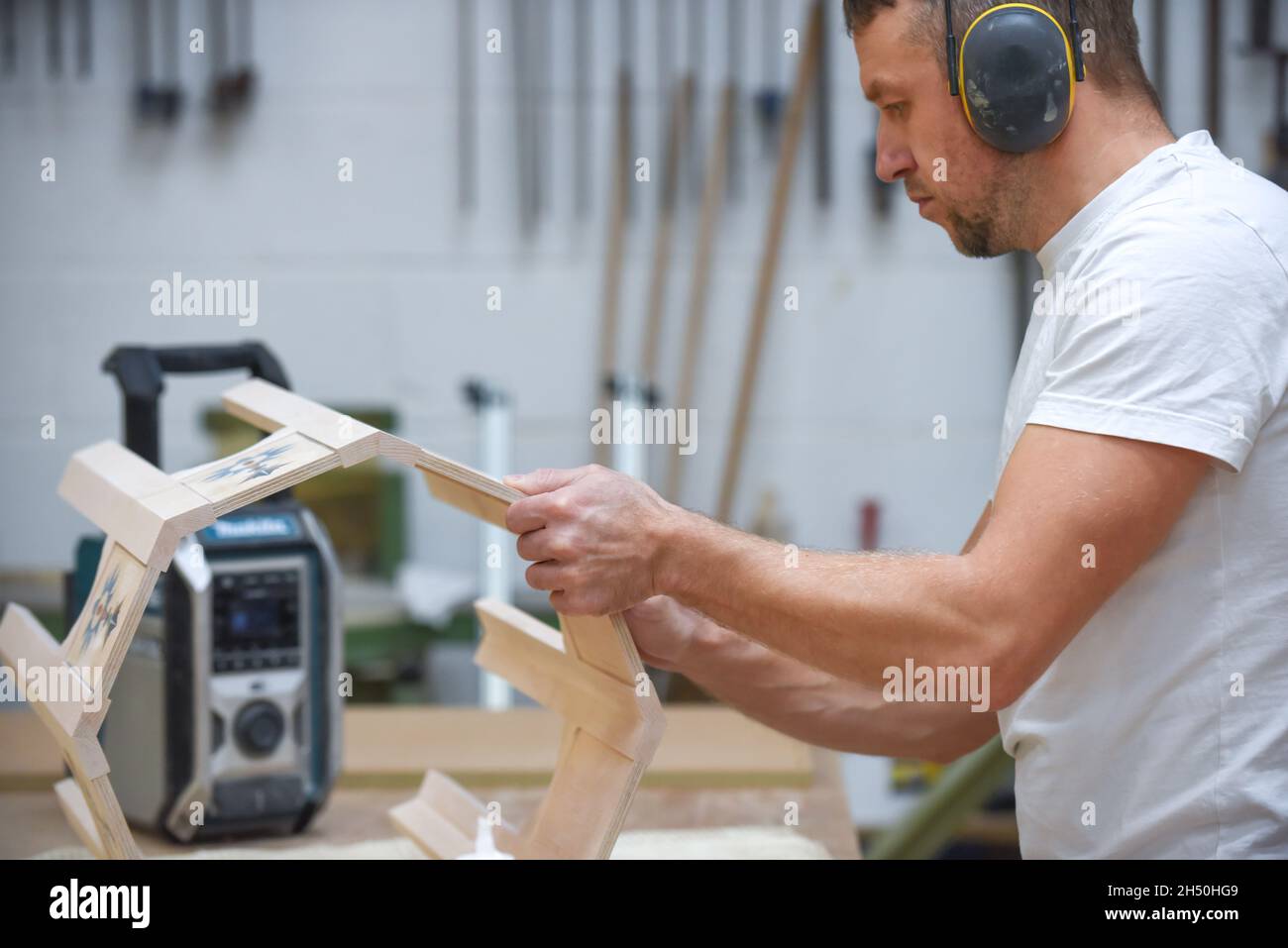 A man is making bespoke furniture in a woodwork showing the construction process Stock