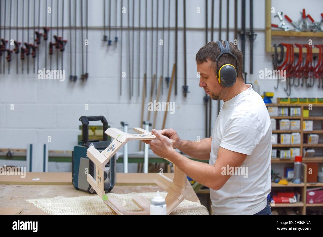 A man is making bespoke furniture in a woodwork showing the construction process Stock