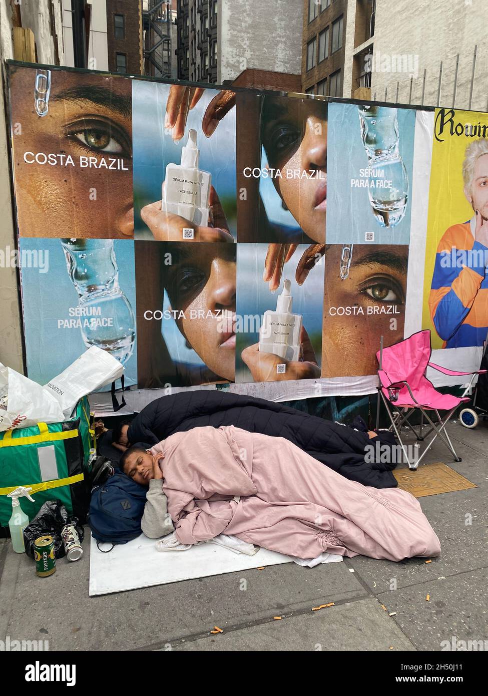 Two homeless people sleep along 6th Avenue in midtown Manhattran in the