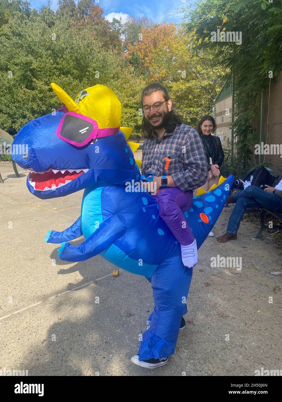 Man rides his pet T. Rex for Halloween at a playground in Prospect Park, Brooklyn, New York. Stock Photo