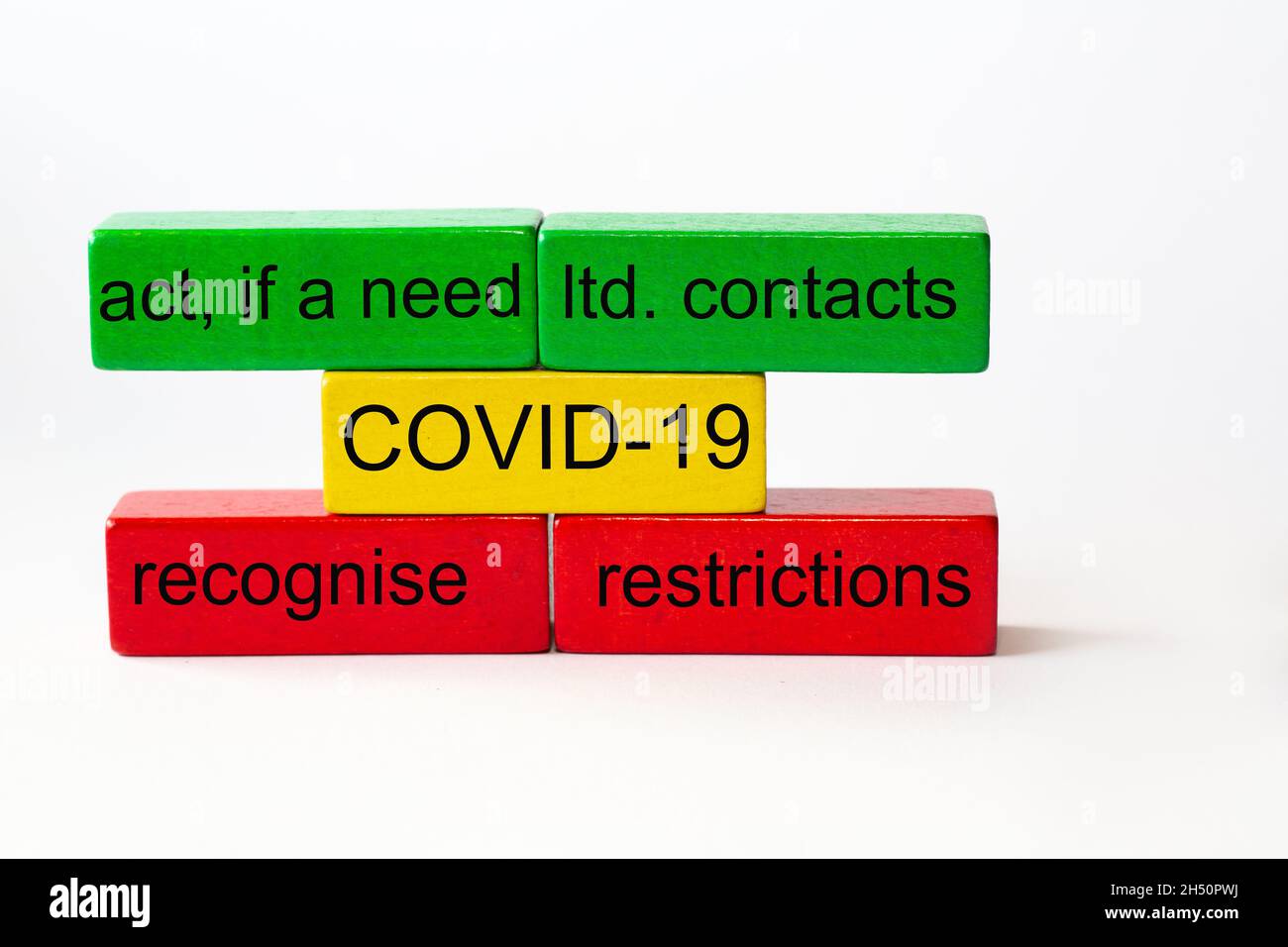 colored toy blocks with the words ltd. contacts, restrictions, recognise, act, if a need and the word COVID-19 in the middle Stock Photo