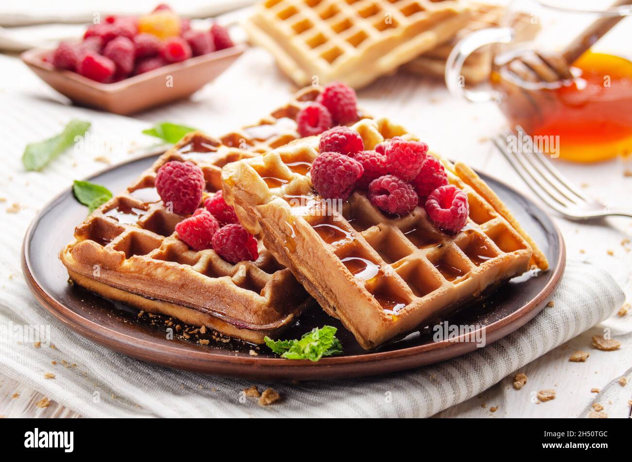 Homemade crispy Belgian waffles served with raspberries and honey Stock