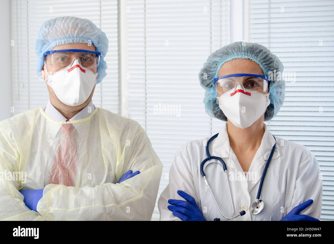 Male and female health care workers in masks glasses caps and gloves