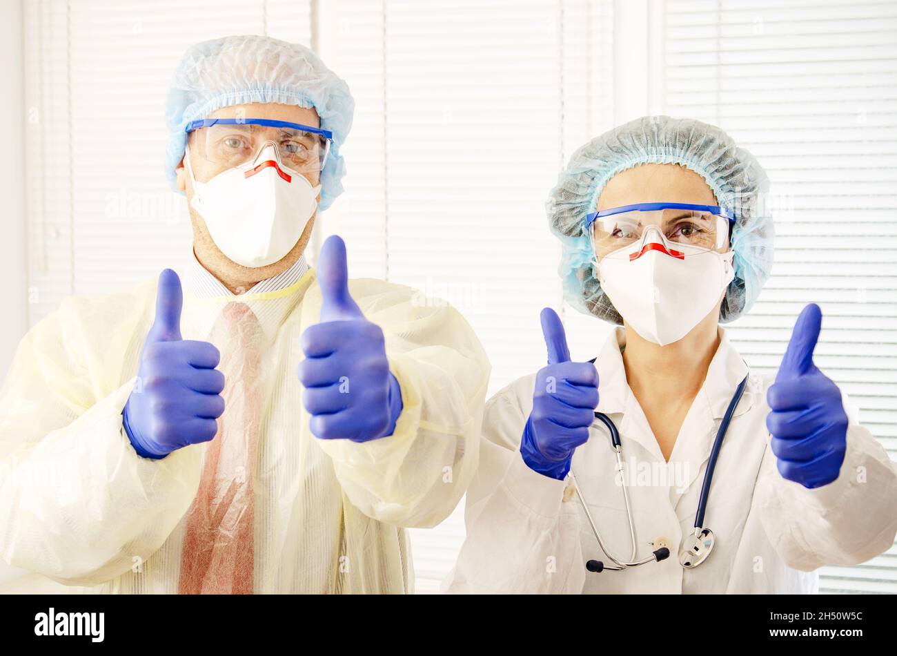 Male and female health care workers in masks glasses caps and gloves
