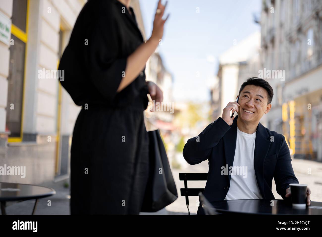 Man talking on smartphone and looking on woman Stock Photo