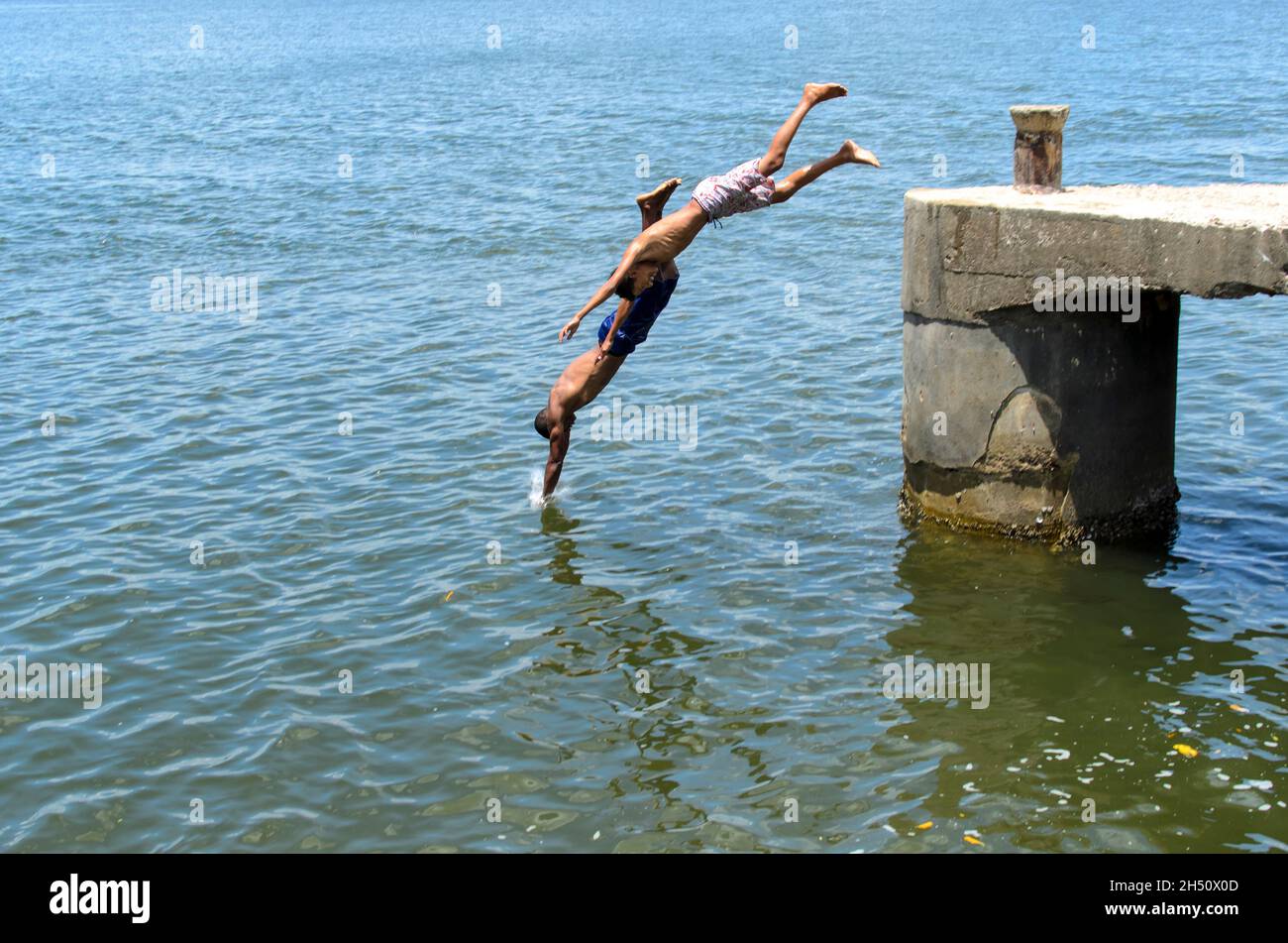 Cachoeira, Bahia, Brazil - November 29, 2014: Young people jumping from the deck of the Paraguacu River in Barra de Paraguacu, located in the Brazilia Stock Photo