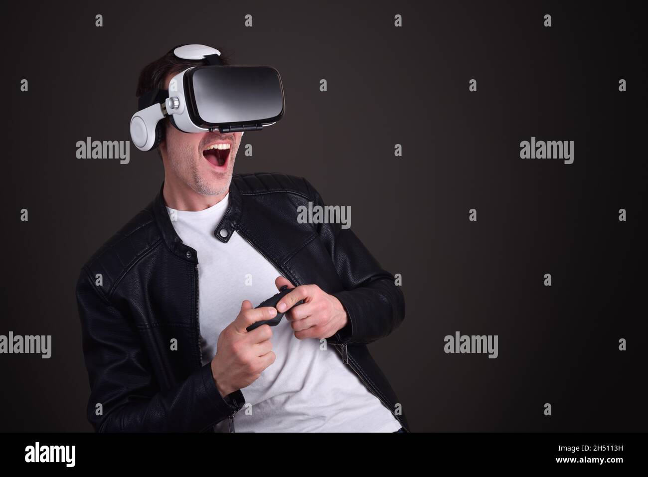 Man having fun dressed casual playing with virtual reality glasses with black isolated background Stock Photo