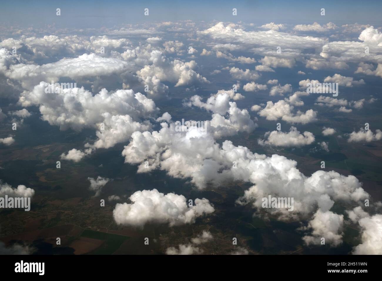Aerial view from airplane window of white puffy clouds on bright sunny ...