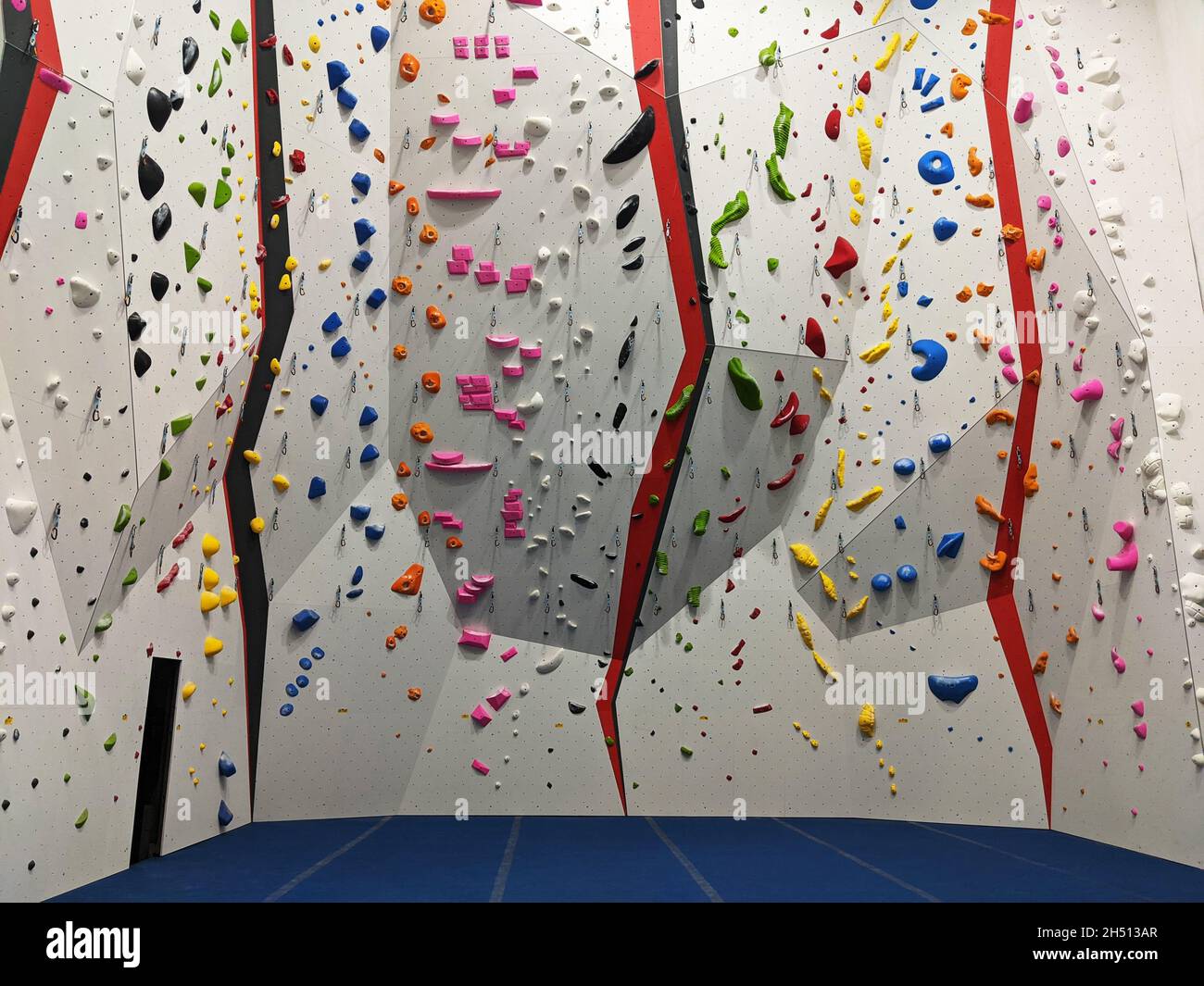 Indoor bouldering and climbing wall for training at a modern gym Stock