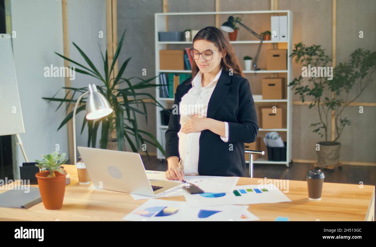 Beautiful Young Pregnant Woman at Work in a Comfortable Modern Office