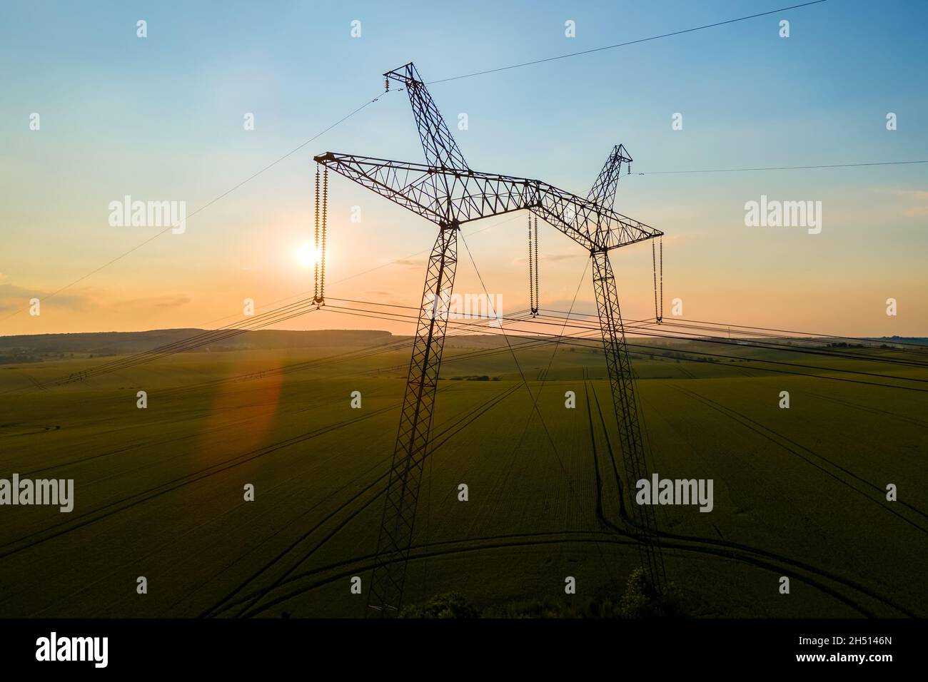 High voltage towers with electric power lines at sunset Stock Photo - Alamy
