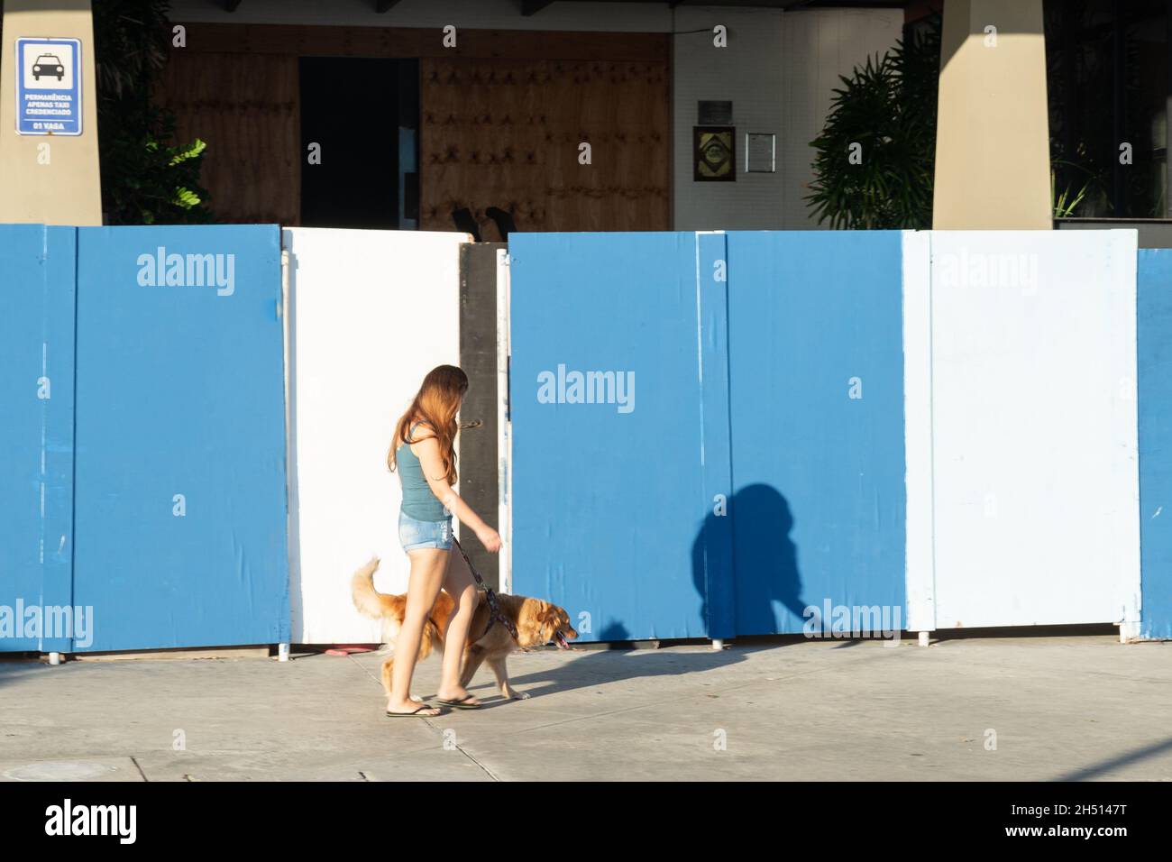 Salvador, Bahia, Brazil - June 17, 2021: Woman walking her dog through the streets of Bairro da Barra. Stock Photo