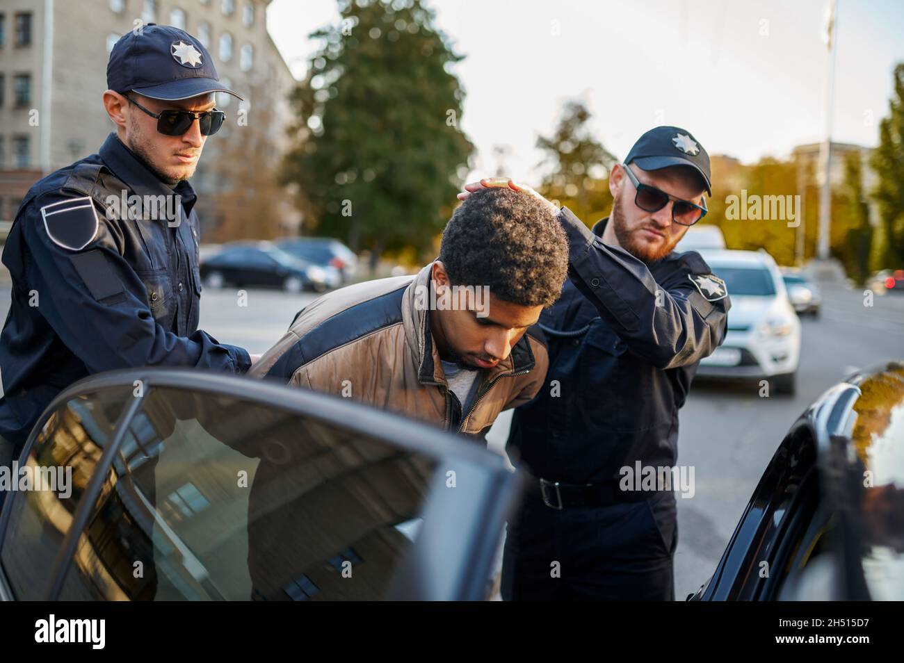 Two male police officers arrest young man Stock Photo - Alamy