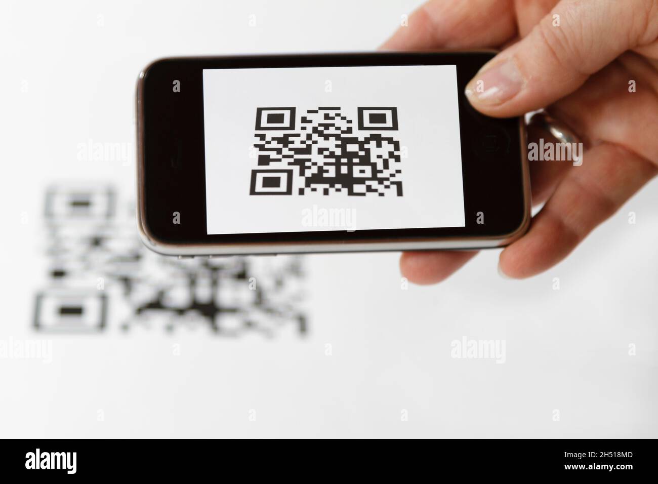 A cellphone in hand while scanning a QR code Stock Photo