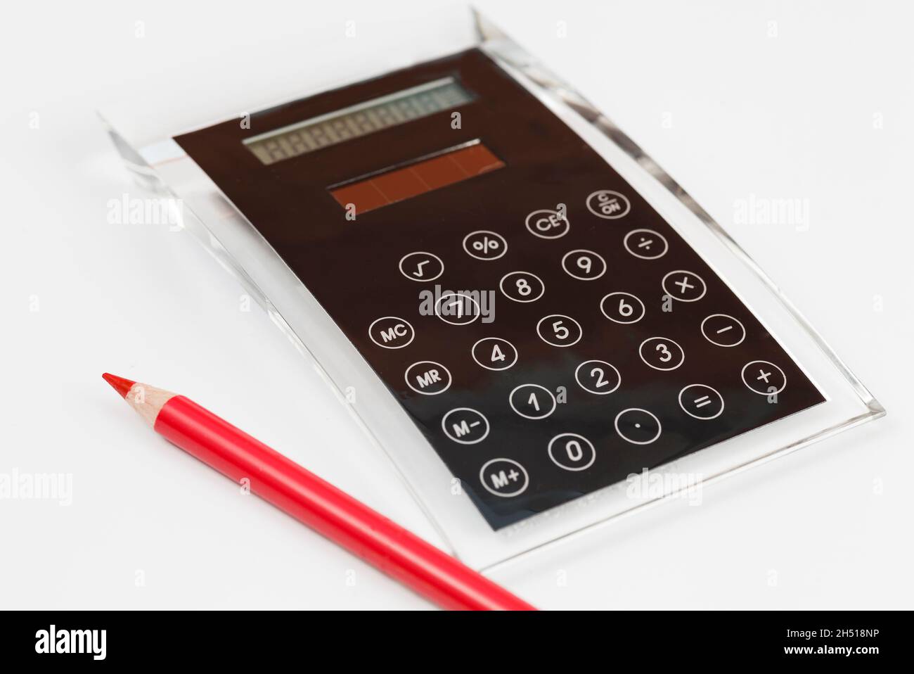 Black design calculator made of acrylic glass with integrated keyboard and red pen Stock Photo