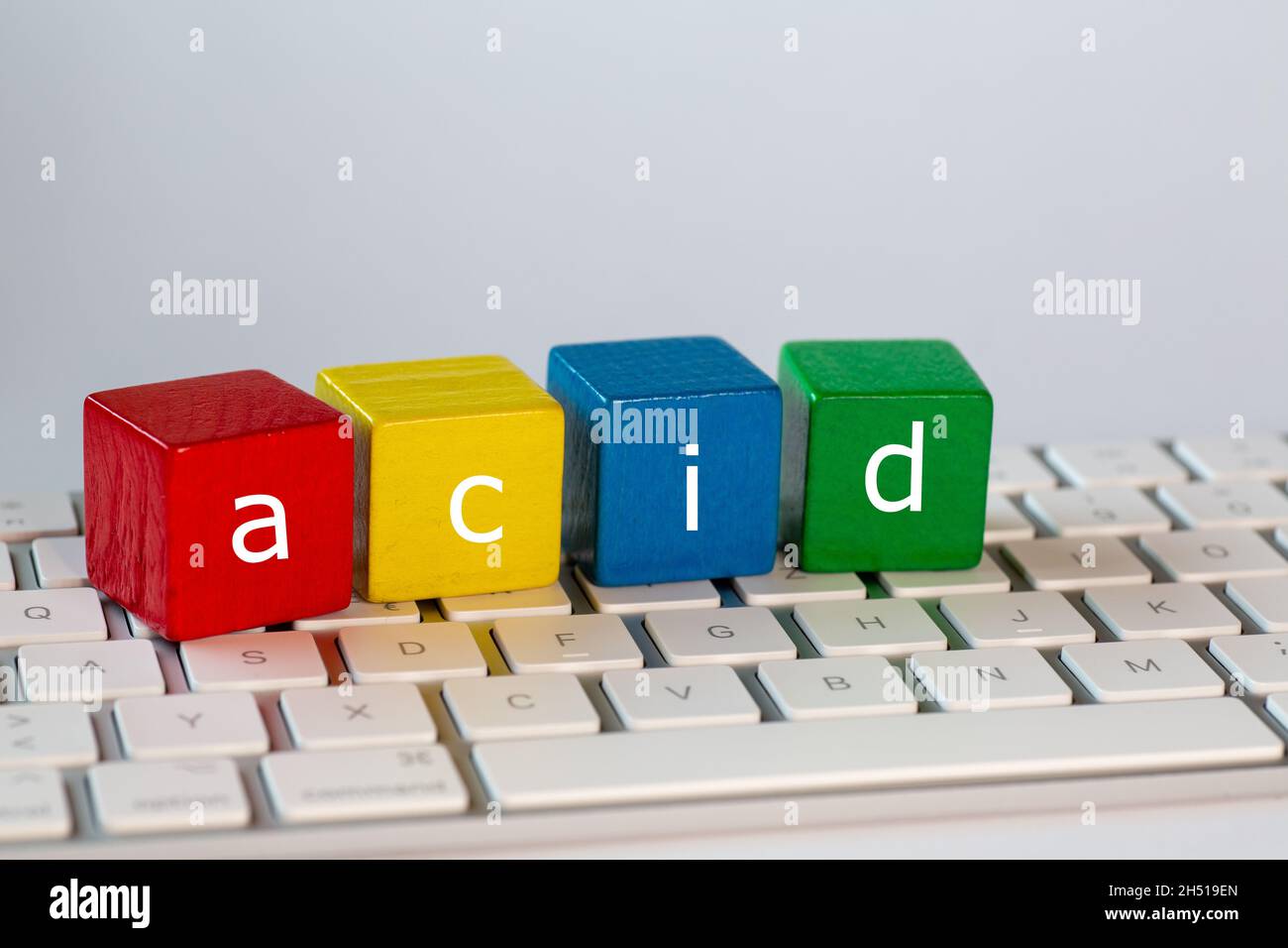The letters acid stands for  Atomicity Consistency Isolation and Durability was written on blocks. Letters are written in white on red, yellow, blue a Stock Photo