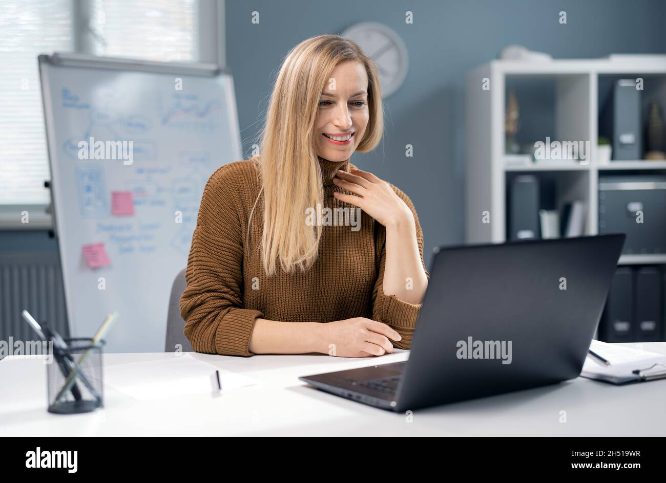 Happy woman working on laptop Stock Photo