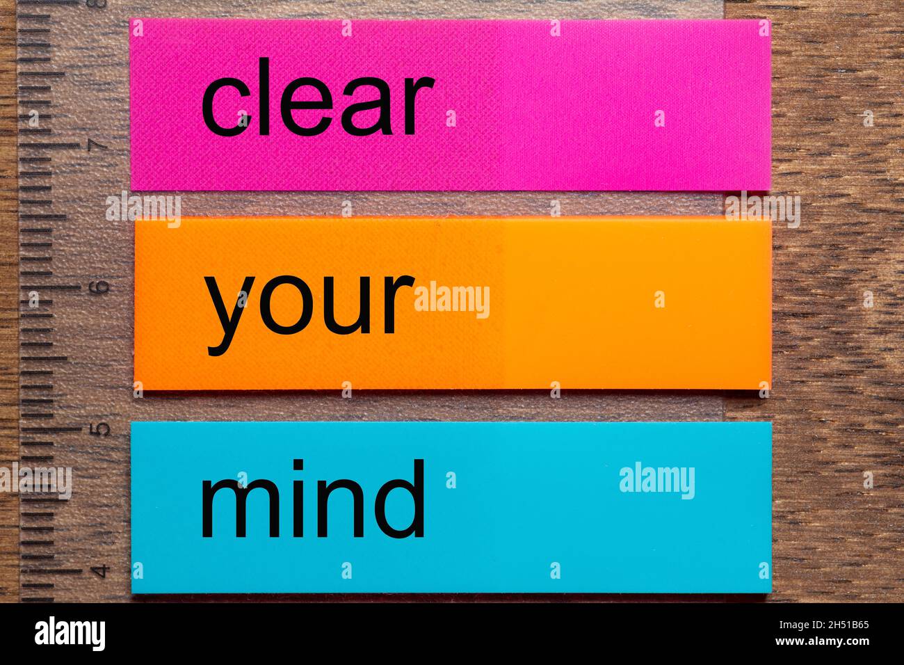 Three bookmark stickers with the word clear your mind on a dark natural wooden table Stock Photo