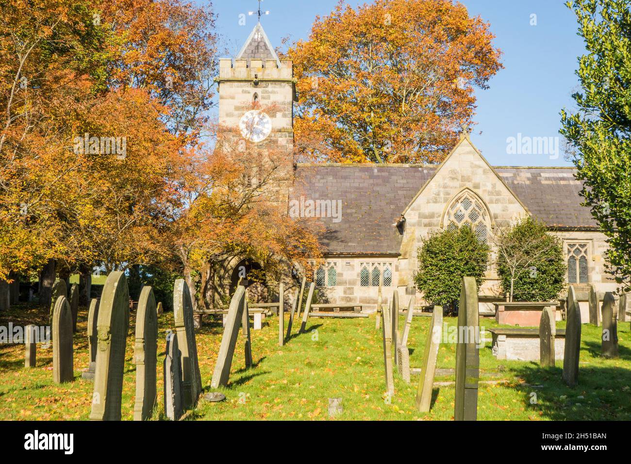 St Peter's parish Church churchyard and gravestones in the Autumn in the Cheshire village of Delamere, Stock Photo