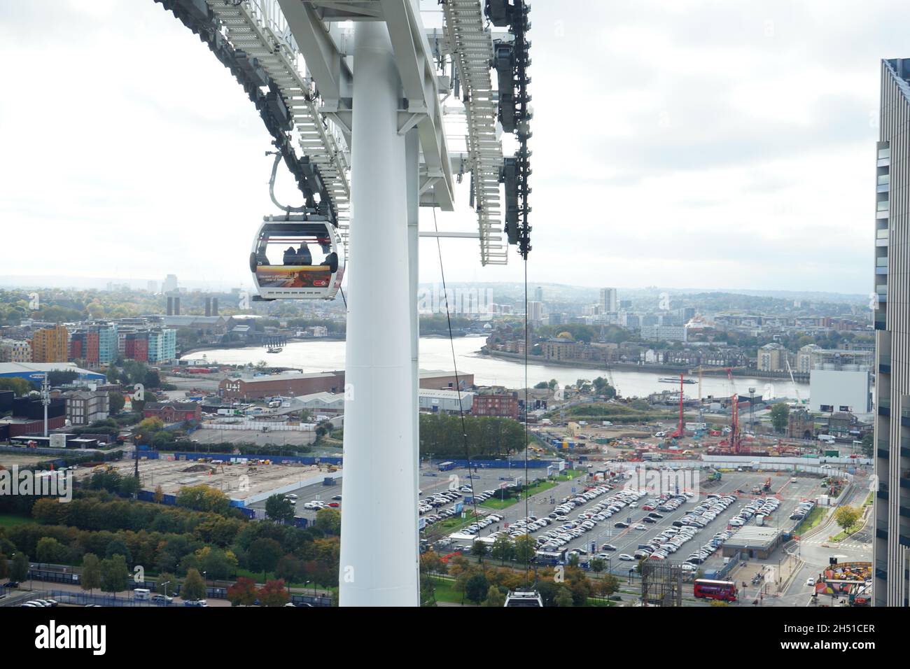 Emirates cable car zip lining over London River Thames in he U.K, transporting passengers and tourists from the O2 Centre Stock Photo