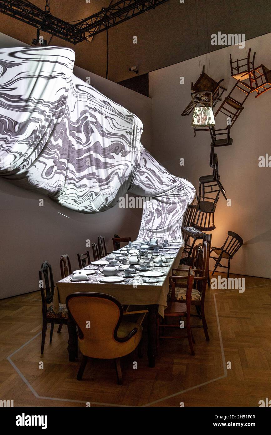 Heston Blumenthal and Dave Mckean’s re-imagination of the Mad Hatter’s tea party, patterns are projected onto white tableware, 'Alice: Curiouser and Curiouser' 2021 exhibition at the V&A, London, UK Stock Photo