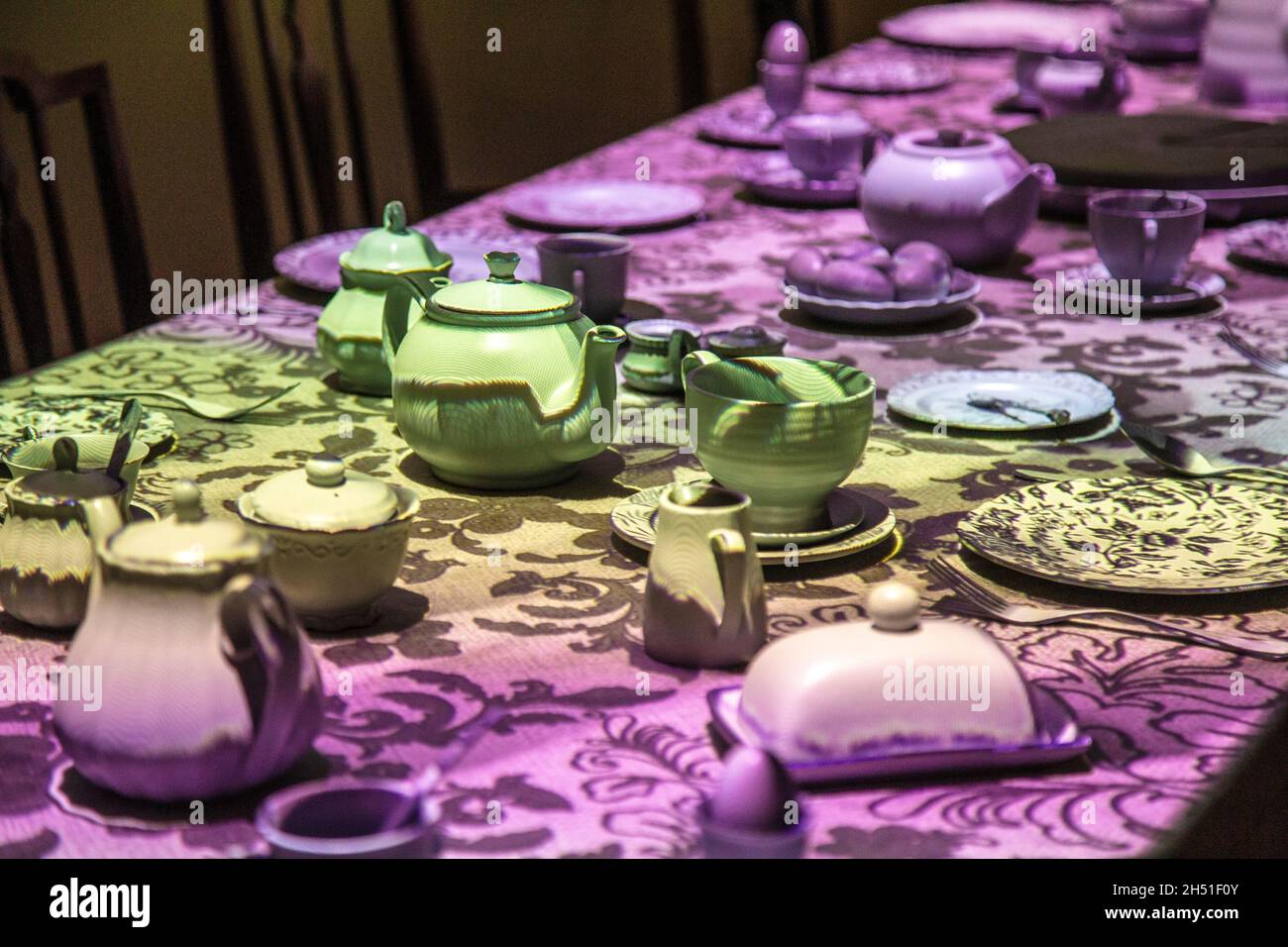 Heston Blumenthal and Dave Mckean’s re-imagination of the Mad Hatter’s tea party, patterns are projected onto white tableware, 'Alice: Curiouser and Curiouser' 2021 exhibition at the V&A, London, UK Stock Photo