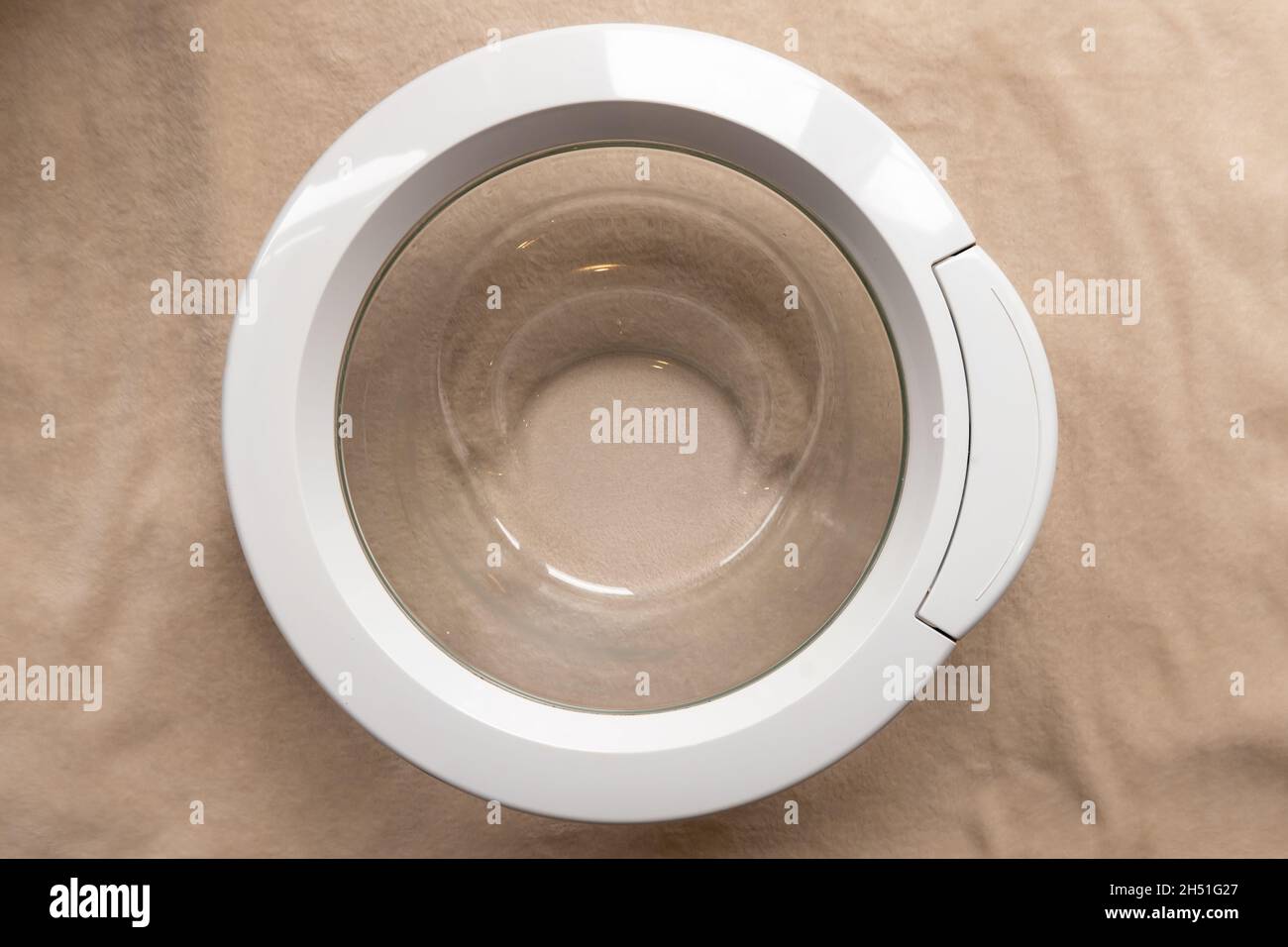 Loose unattached washing machine door frame and glass with handle from