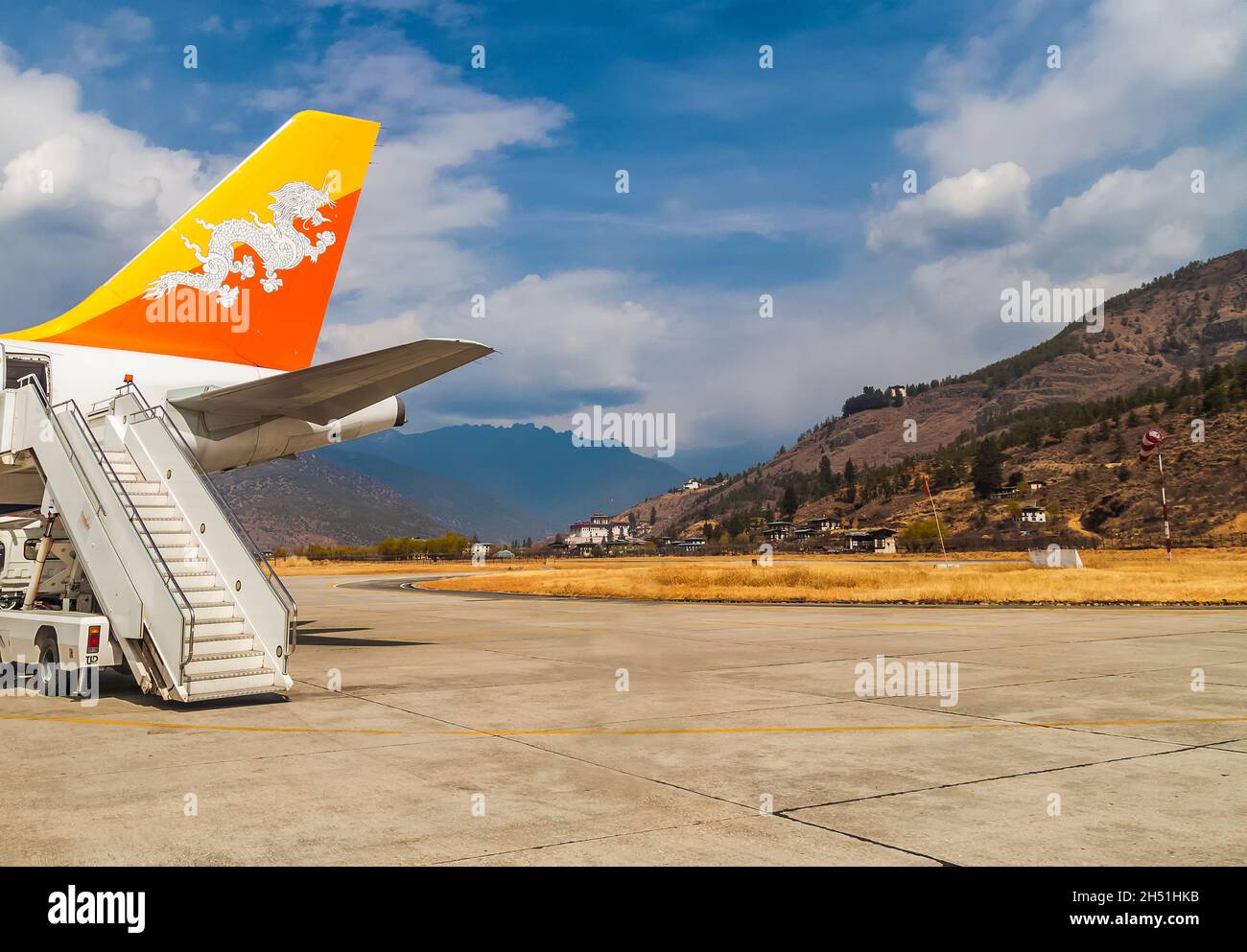 Paro/ Bhutan - February 26, 2016: Tail and ladder of Drukair - Royal Bhutan Airlines Airplane Airbus A319s in Paro Airport. Himalaya mountais and bhut Stock Photo