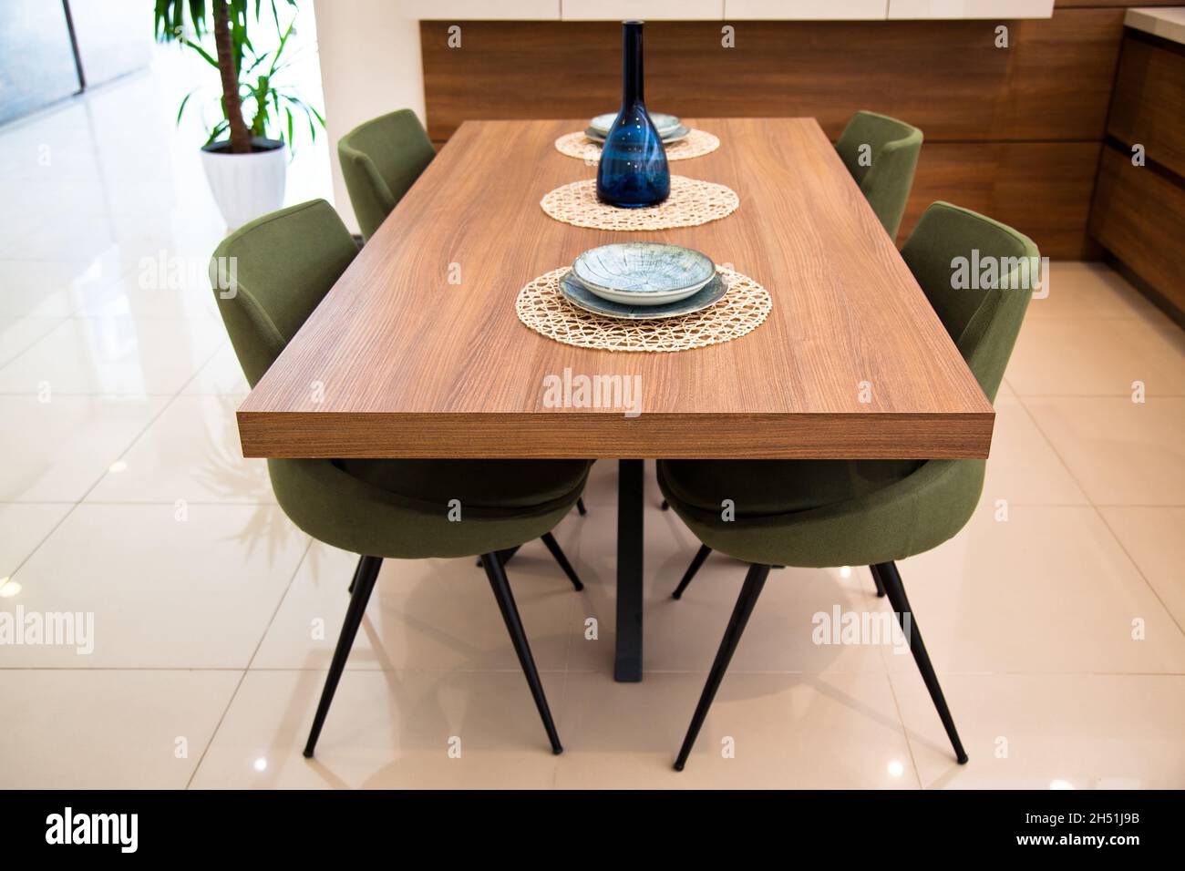Modern kitchen interior area, wooden walnut dining table and green ...