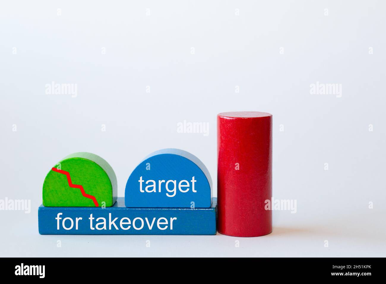 toy blocks form a factory. The red curve shows rapidly below. Text: target for takeover Stock Photo