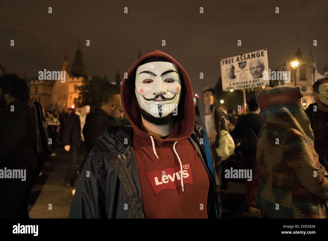 London, UK. 05th Nov, 2021. A demonstrator is seen wearing the Anonymous mask during the Guy Fawkes night.Guy Fawkes Night is an annual celebration in memory of the Gunpowder Plot, an attempt to burn down the Parliament in London on 5th Nov 1605. The protest was held by anti-establishment hacktivist group Anonymous. Demonstrators are seen setting fireworks and gas bombs outside Parliament while wearing the Guy Fawkes Mask. Credit: SOPA Images Limited/Alamy Live News Stock Photo