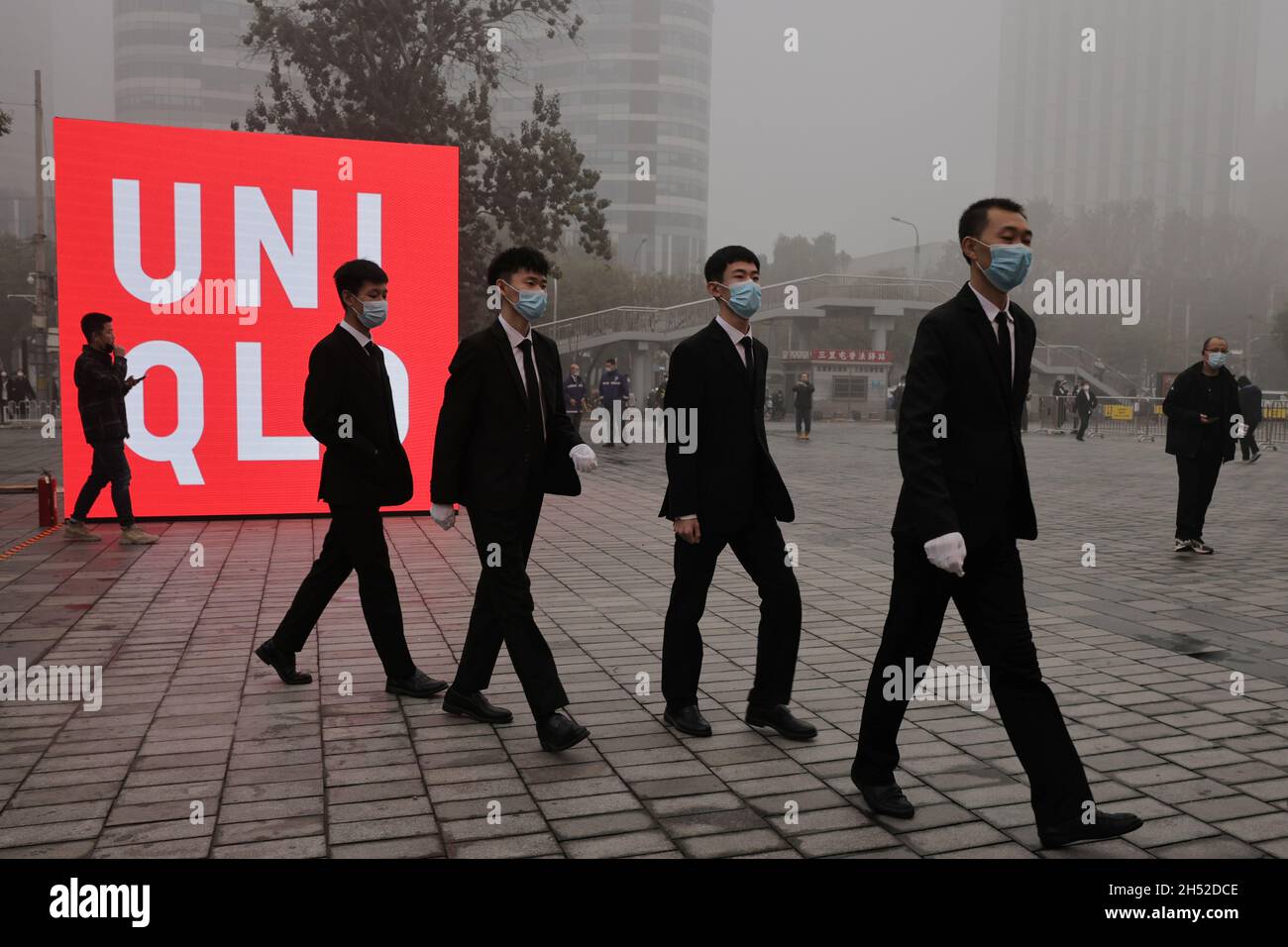 Security staff enter a store of the Uniqlo fast fashion retailer before its  opening in the