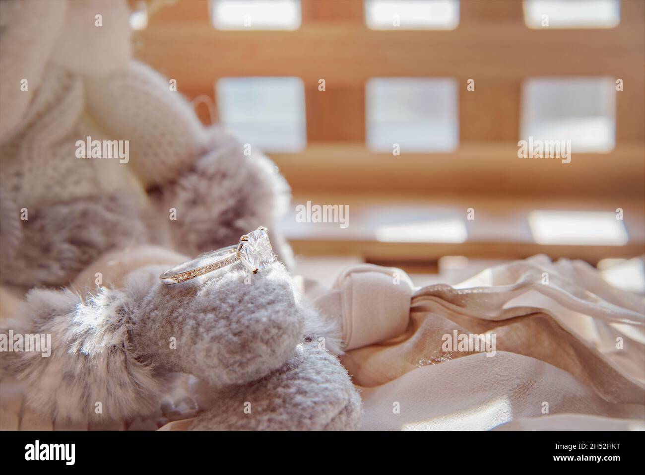 Close-up of Elegant Diamond Ring on Gray Scarf background. Luxury Diamonds Jewellery Accessory. I Love You Darling Concept. Stock Photo