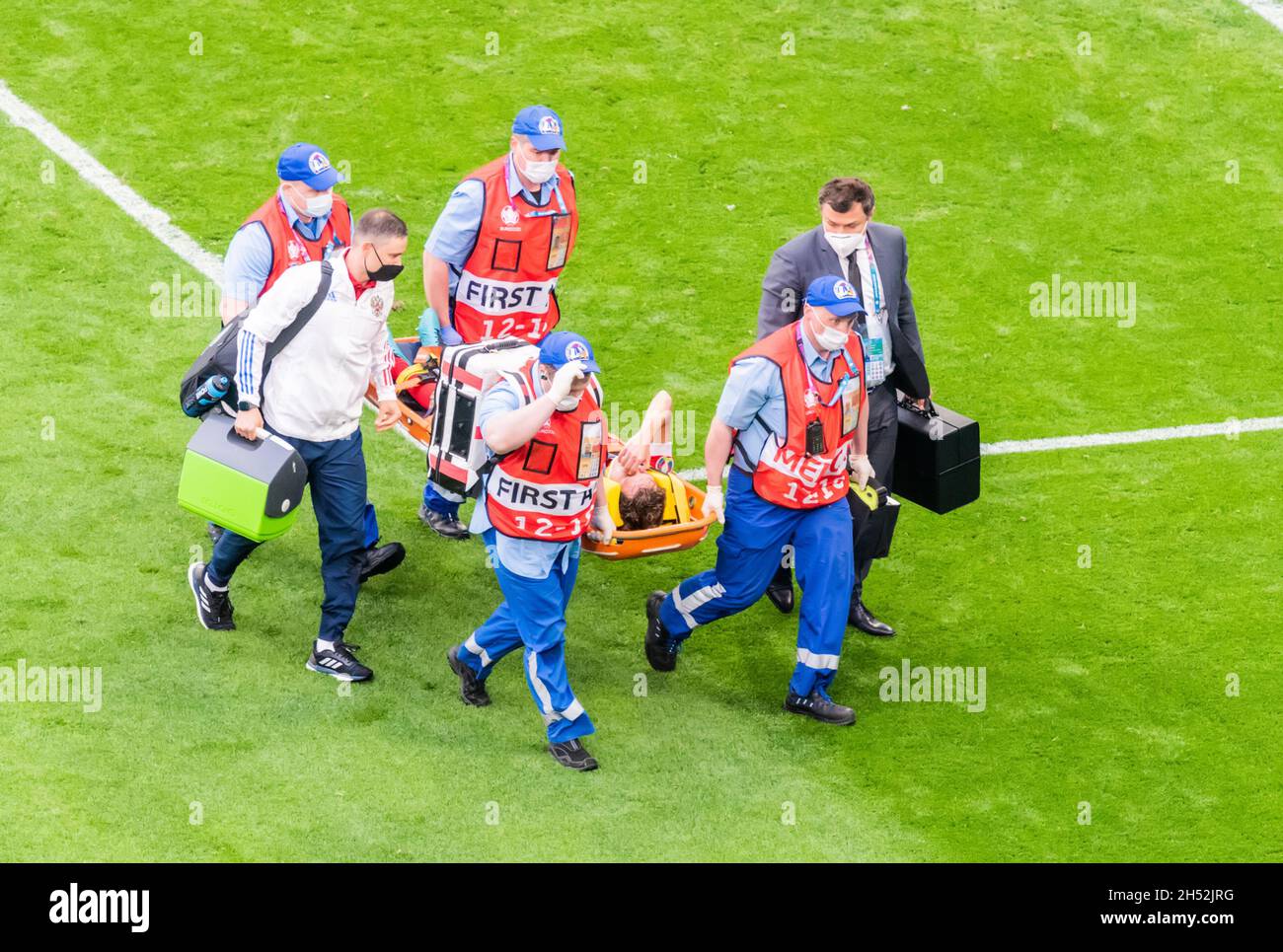 Saint Petersburg, Russia – June 16, 2021. Medical staff stretching Russia defender Mario Fernandes off the pitch after injury during EURO 2020 match F Stock Photo