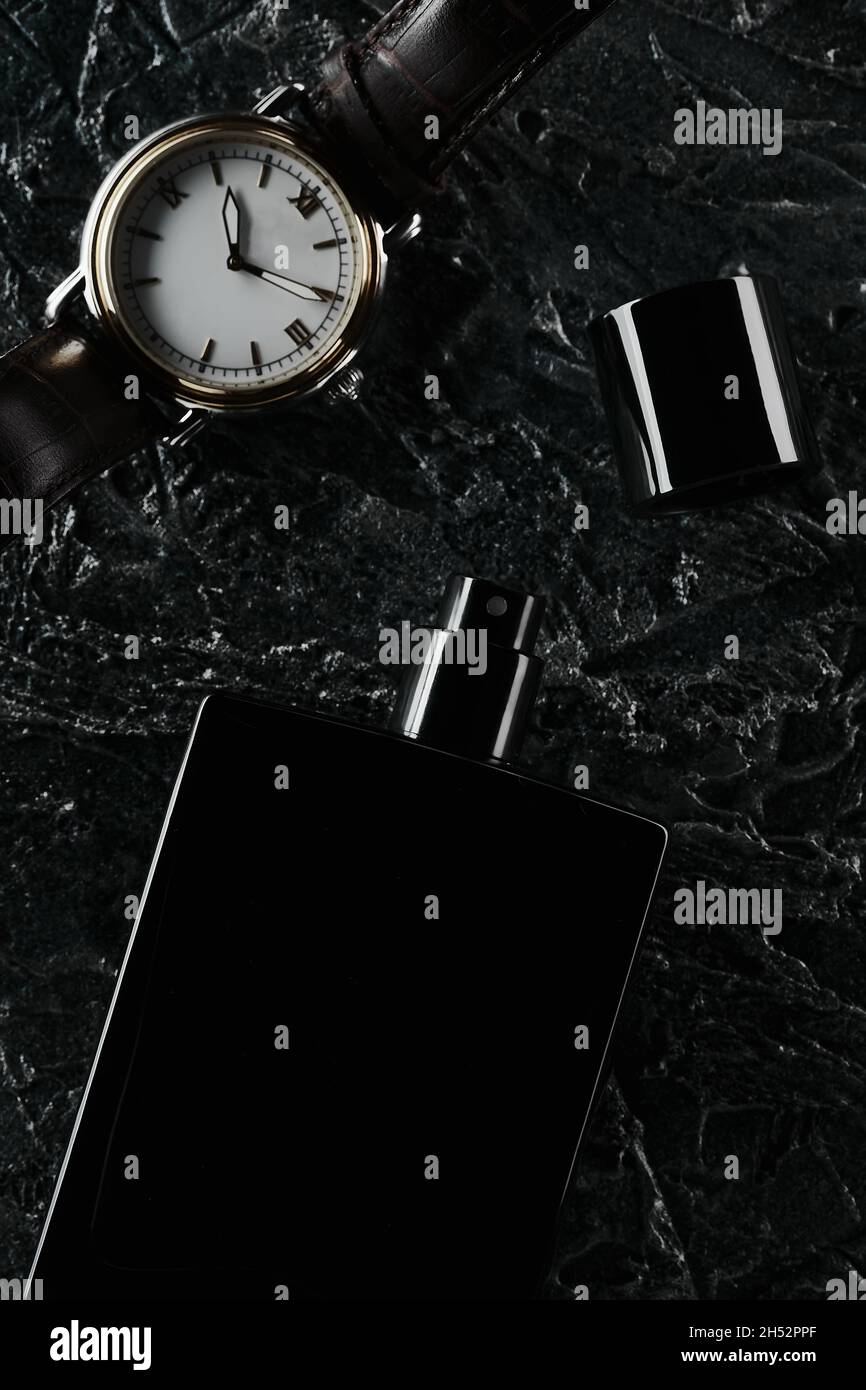 Men's watches and an open bottle of black eau de toilette lie on a dark  textured background. Fragrance for men. flat lay Stock Photo - Alamy