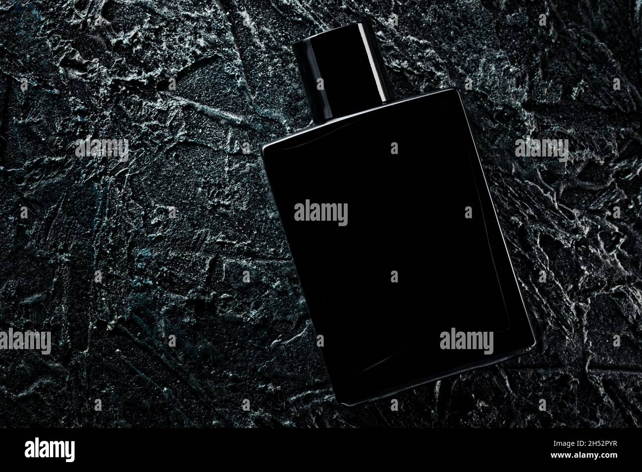 Men's fragrance of perfume or eau de toilette. Promotional photo of a black  bottle on a dark background. Layout for copying text Stock Photo - Alamy