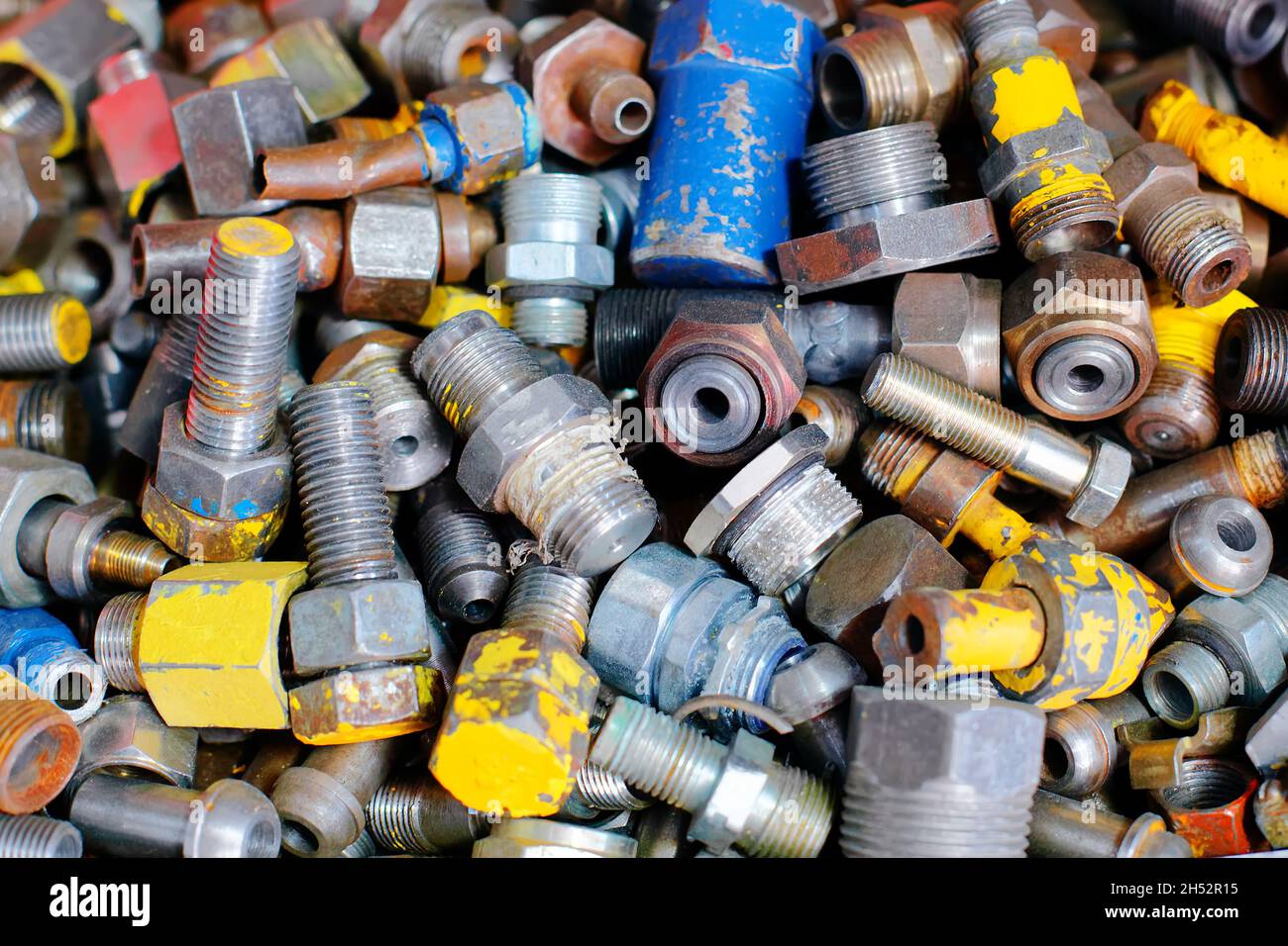 These old and used metal bolts and nuts lie together. Solid background