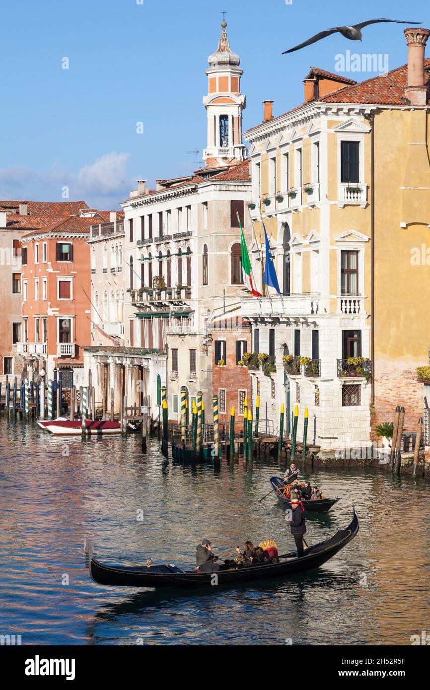Tourists enjoying an evening gondola ride on the Grand Canal, Venice, Veneto, Italy with palazzos in Cannaregio beyond Stock Photo
