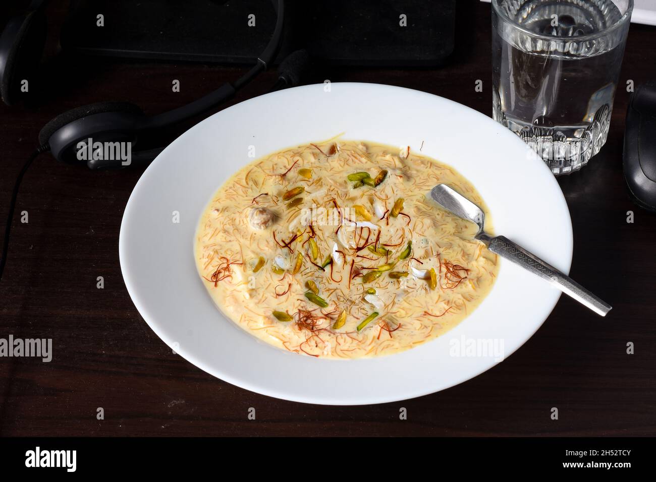 Sheer Khurma prepared with milk and vermicelli, garnished with saffron, pistachios and nuts. Stock Photo