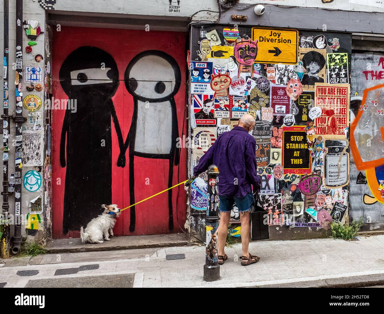 Dog walker and Stik street art Brick Lane Stock Photo