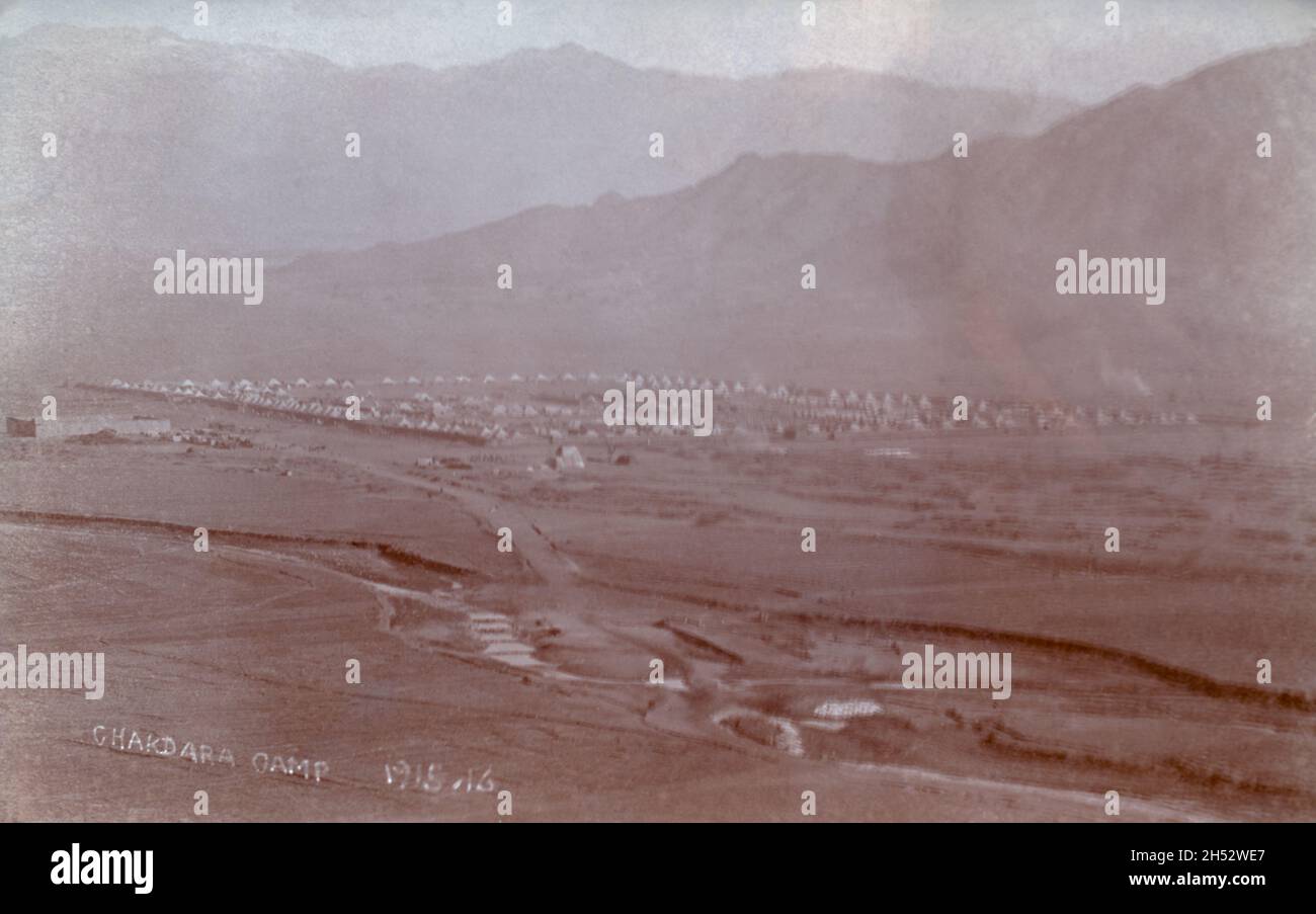 A historical landscape view of the British army and British Indian army Chakdara camp in 1915-1916 on the North-West Frontier of British colonial India. The campaign, during the First World War, involved defending India from tribal attacks coming from Afghanistan. On the reverse it is stated that Luke Biggins was one of the soldiers at the camp. Stock Photo