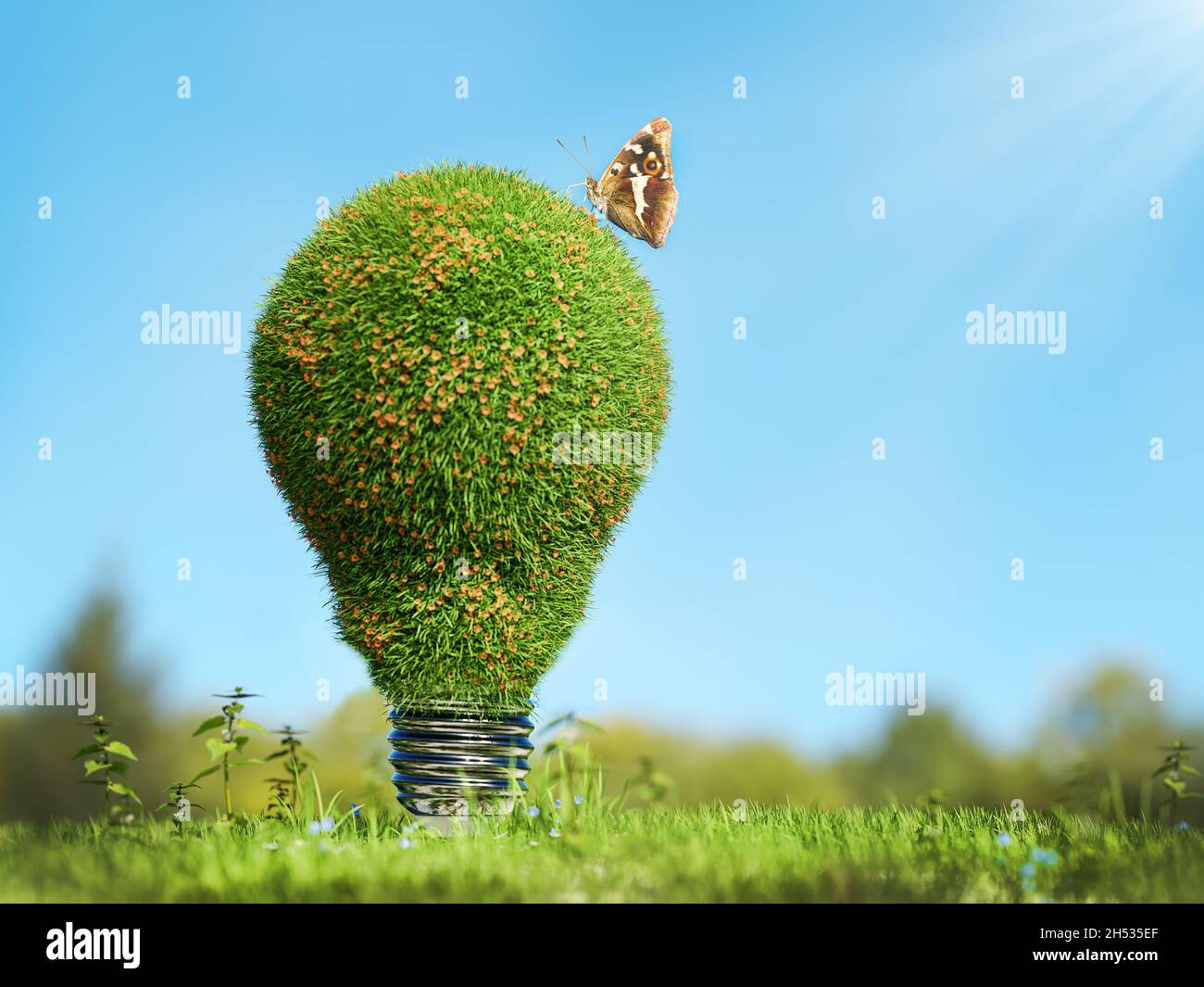 3D rendering of lightbulb covered with grass resting in grassy field against blue sky - green energy concept Stock Photo