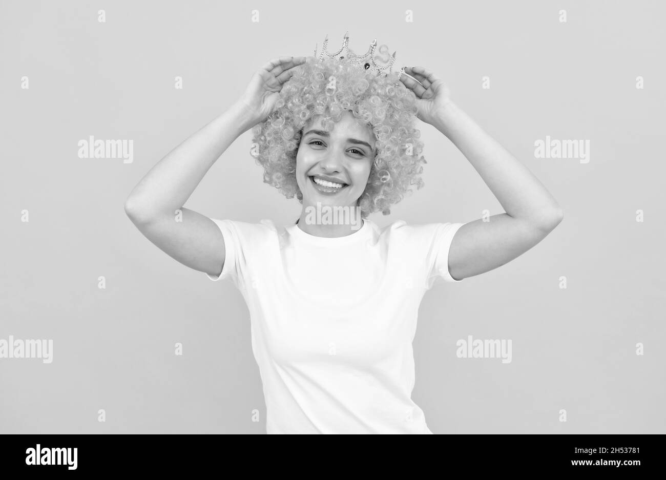look what i have. birthday party goer. happy funny woman in curly wig and crown. Stock Photo