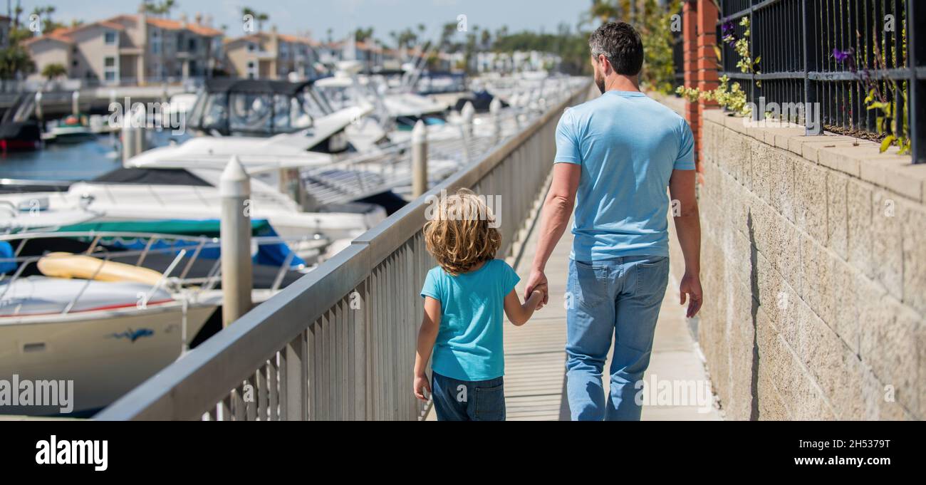 single father leading small child outside back view, togetherness Stock Photo