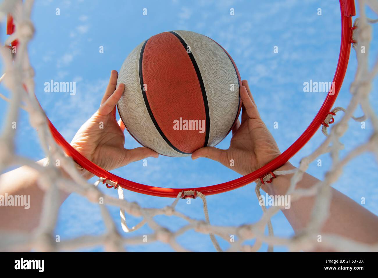 scoring during basketball game. ball goes through basket. man throwing